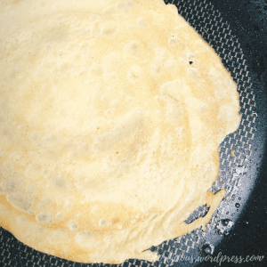 A lightly browned crepe inside of a frying pan