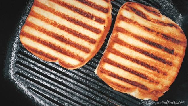 Grilled cheese with grill marks on it inside of a cast iron grill pan