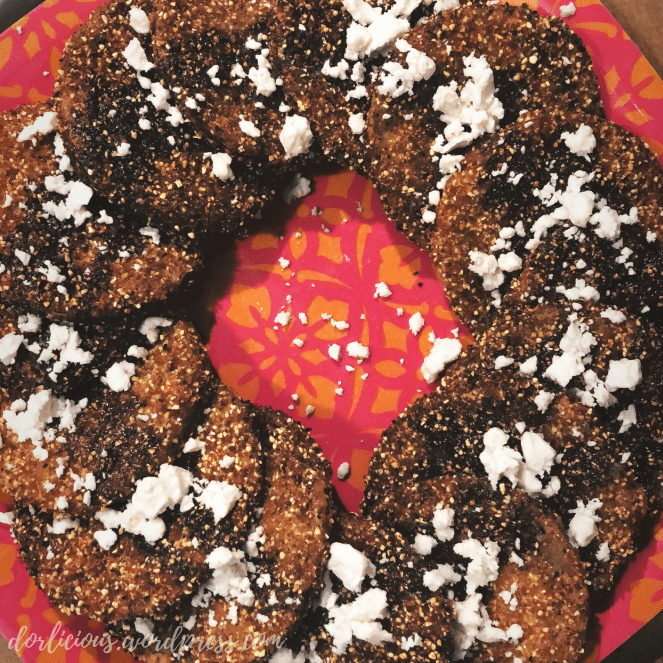 Fried green tomatoes with balsamic reduction and crumbled feta cheese plated and arranged in a ring