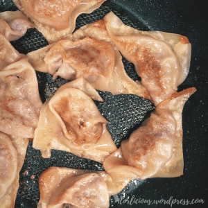 Potstickers in a lightly oiled pan that have been steamed