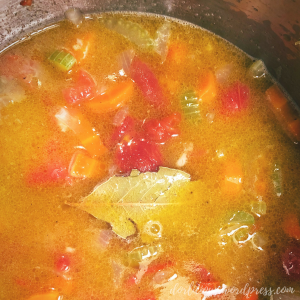 Pot full of tomato juice, chicken broth, melted butter, celery, carrot, onion and tomato