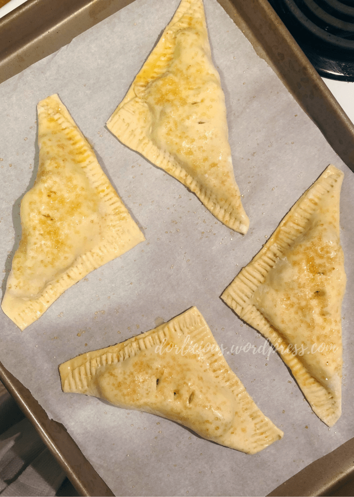 prepared turnovers on a parchment line baking sheet